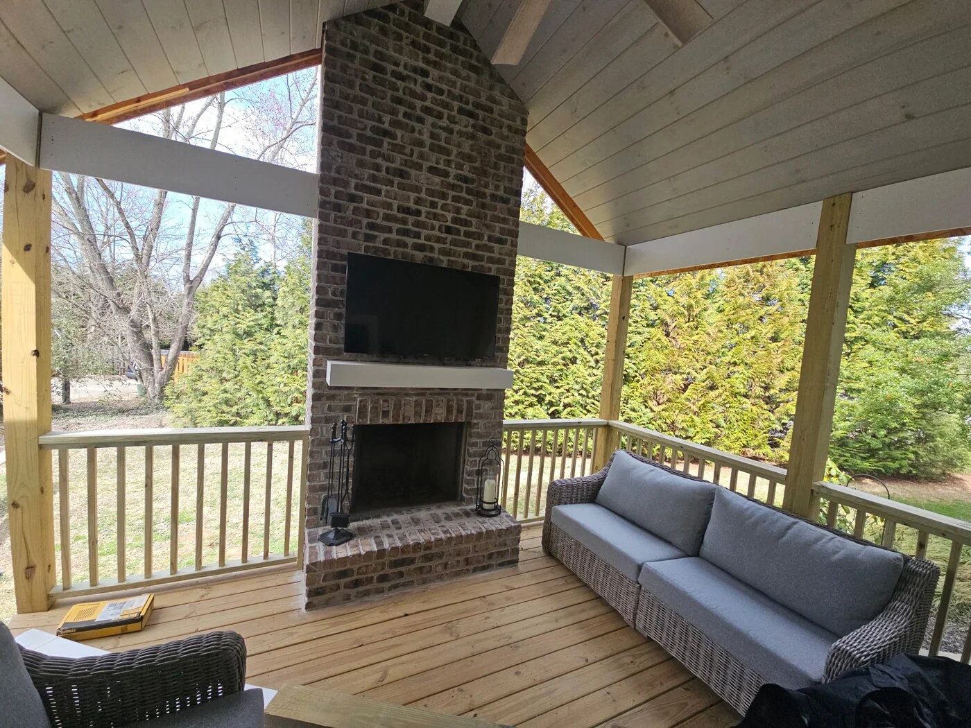 Covered outdoor living space with brick fireplace